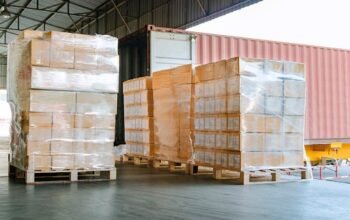 Stack of cardboard boxes on pallet at distribution warehouse for load into container
